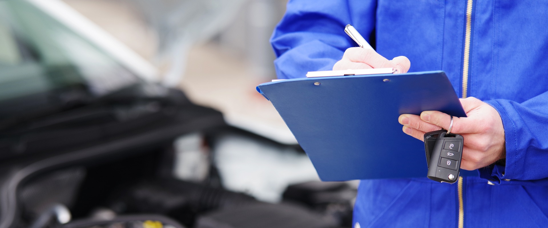 Mechaniker bei der Durchsicht eines Autos, TÜV-Untersuchung